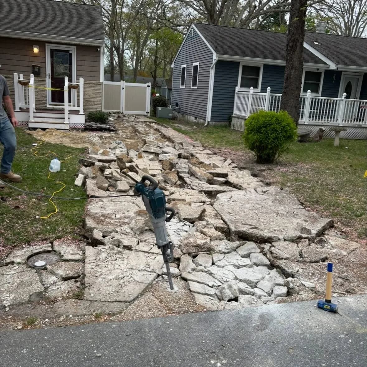 Jackhammer breaking out a cracked old concrete driveway for full tear-out and removal at a South Jersey home