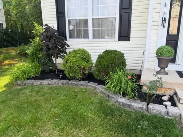 Stone garden bed border with daylilies at a South Jersey home